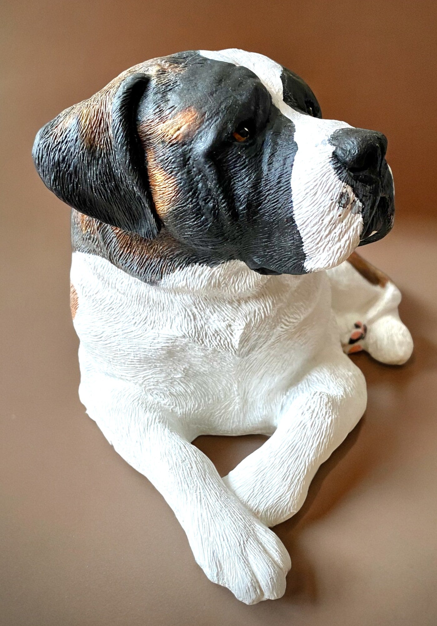 Saint Bernard statue made of concrete commissioned pet portrait of Charlie. Dog statue is laying down. Front right side of statue.