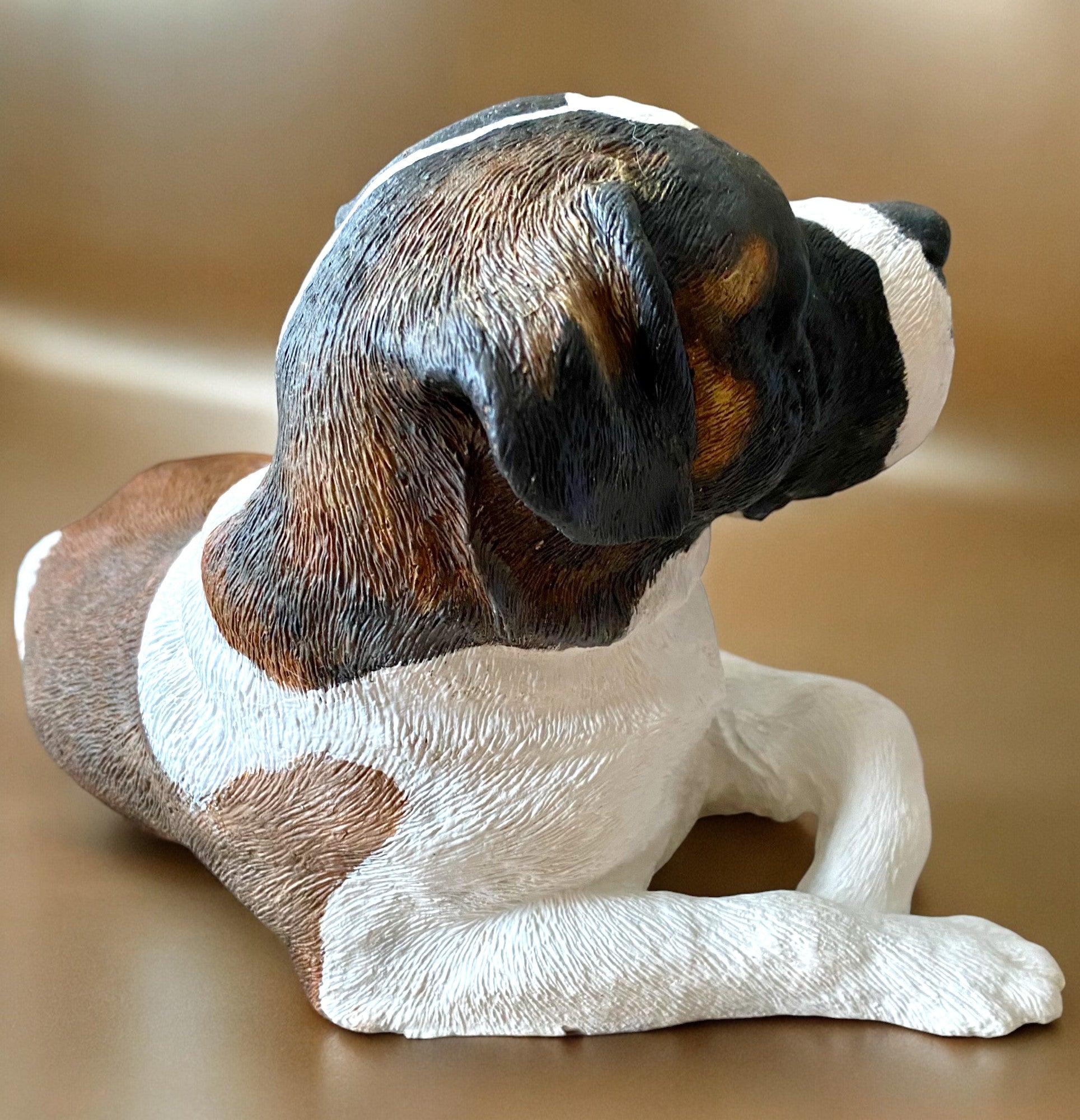 Saint Bernard statue made of concrete commissioned pet portrait of Charlie. Dog statue is laying down. Right side of statue.