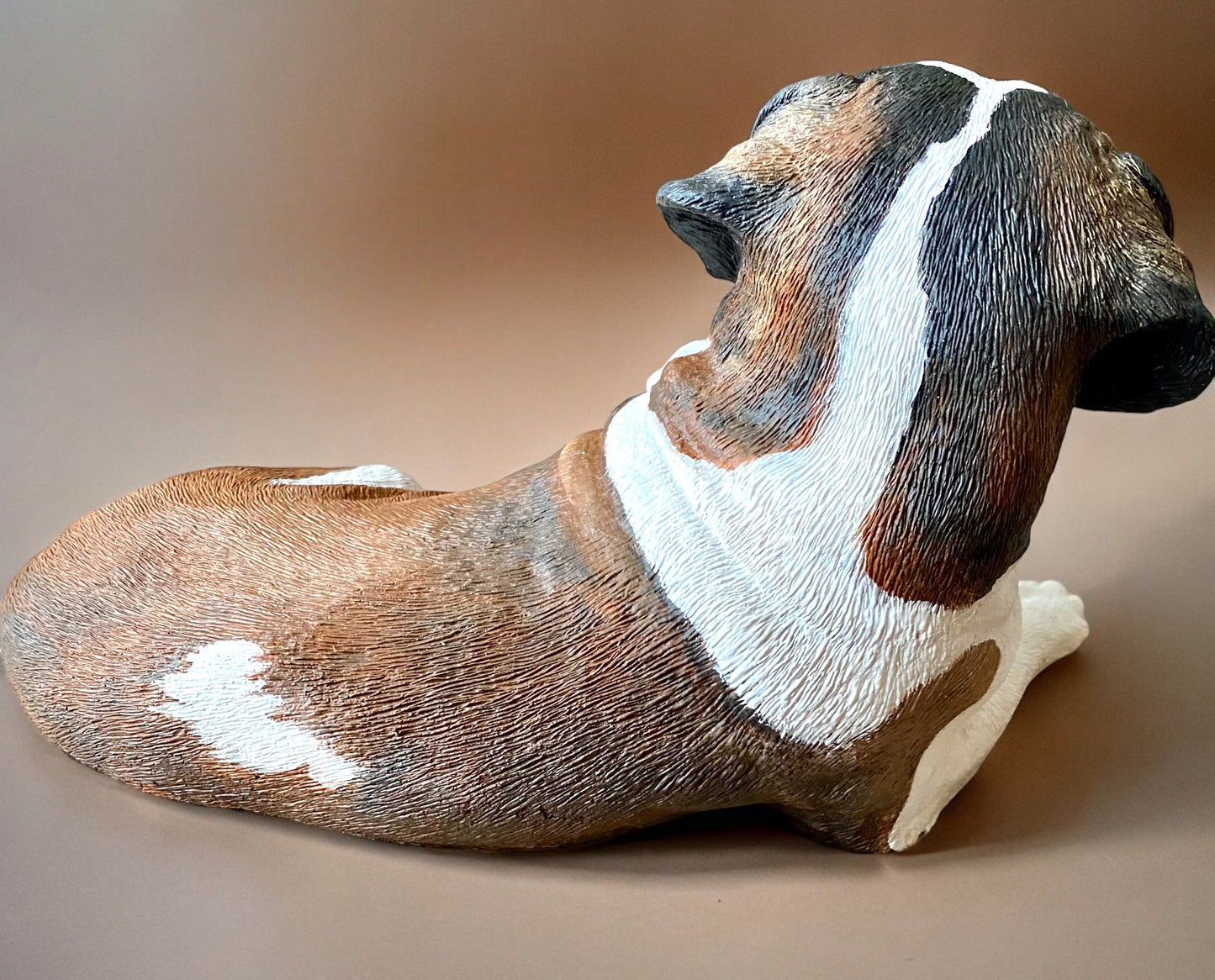 Saint Bernard statue made of concrete commissioned pet portrait of Charlie. Dog statue is laying down. Back view of statue.